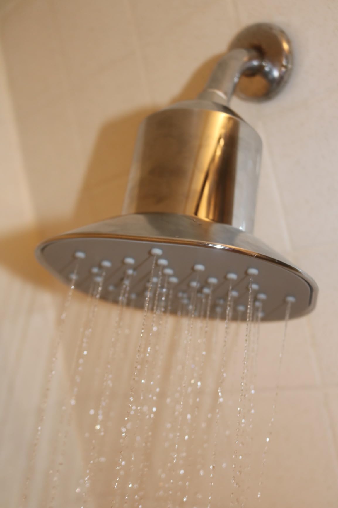 Water flowing from Afina filtered shower head, demonstrating high-pressure performance and sleek chrome finish.